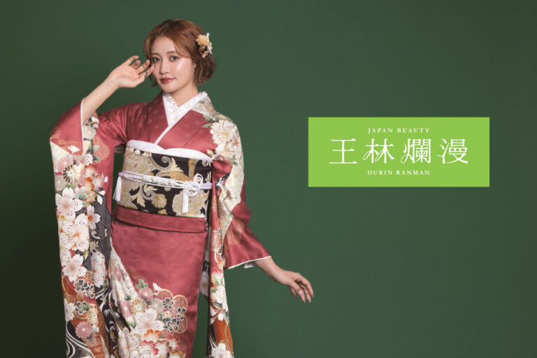 花柄の着物を着た女性が、緑の背景に優雅なポーズをとっています。髪には花を挿し、片手に着物の一部を持っています。右側には、緑の長方形の上に日本語の文字があり、「日本美」と「桜林爛漫」という言葉も書かれています。.