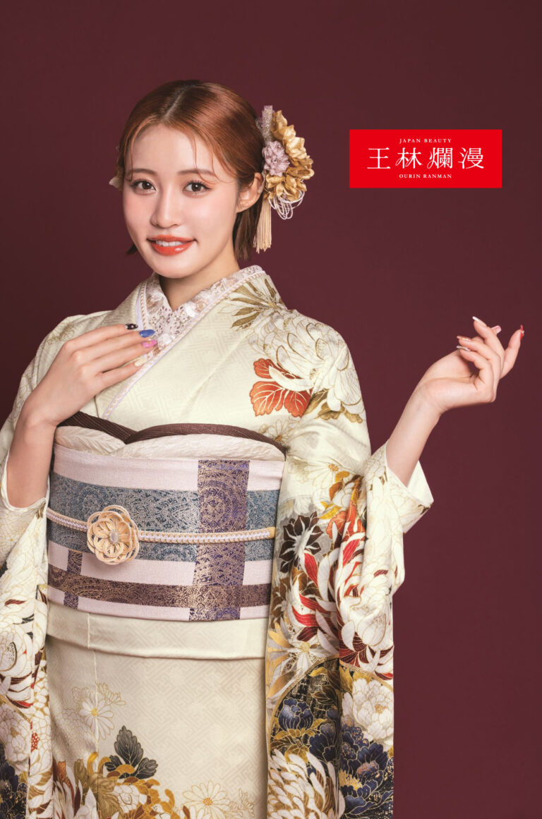 エレガントな花柄の着物を着た女性が栗色の背景にポーズをとっています。着物には複雑な花柄が描かれ、ベージュとブルーの帯には花が飾られています。ヘアピンでアップスタイルにしています。右上隅にアジアの文字のテキストが表示されています。.